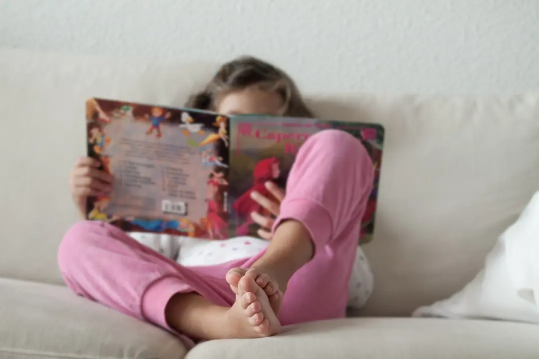 Una ni&ntilde;a leyendo un cuento en su casa
