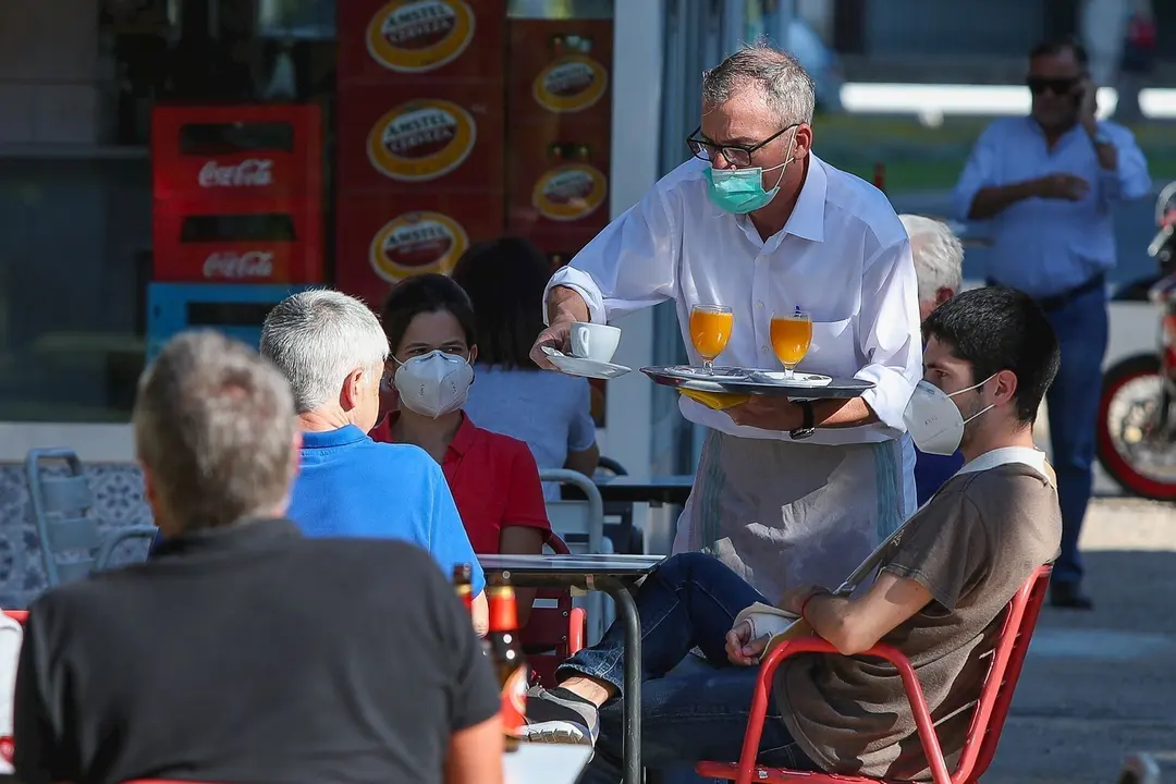Un camarero sirve a los clientes en una terraza de un bar despu&eacute;s de que el Ministerio de Sanidad autorizara a que la totalidad de la Comunidad Valenciana pasase en su conjunto a la fase 1 de la desescalada.  