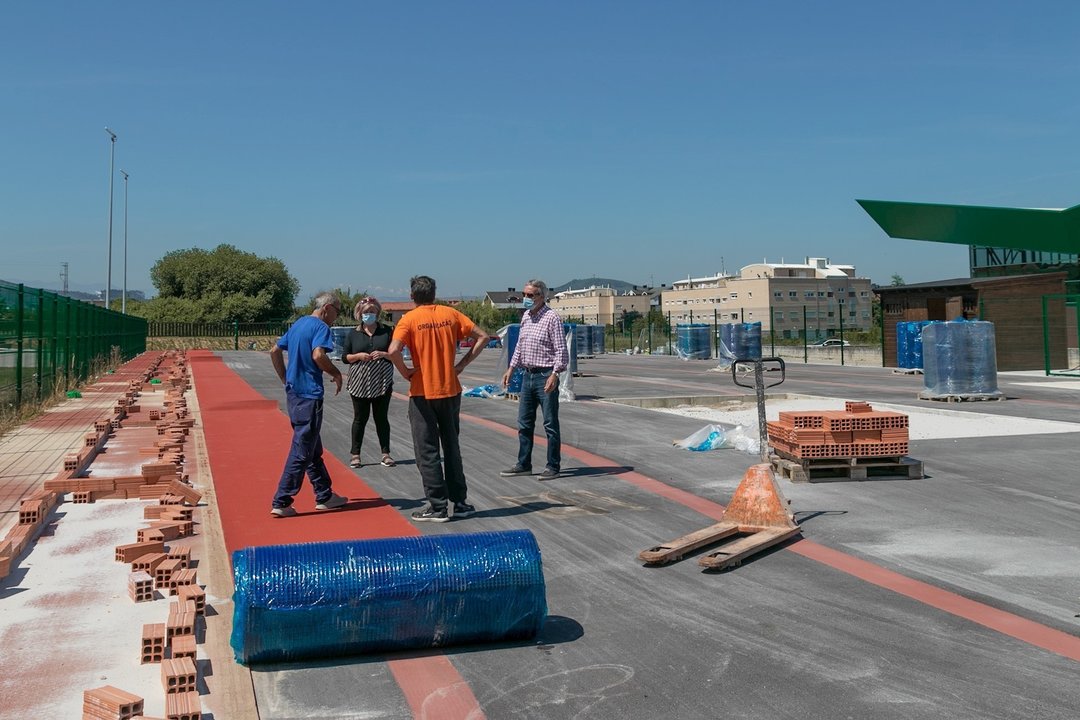 Trabajos de colocación del pavimento de la nueva pista de atletismo en Requejada (Polanco)