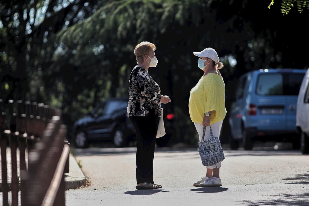 Dos mujeres protegidas con mascarilla mantienen una conversación en una de las calles del municipio de Griñón (Madrid) durante el día 69 del estado de alarma decretado a consecuencia del coronavirus y todavía fase 0 de la desescalada instaurada por el Gob