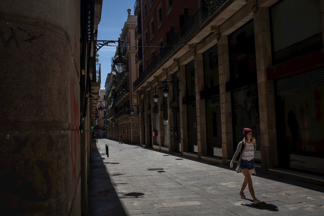 Una mujer pasea por una calle durante el tercer día de desconfinamiento de adultos y durante la fase 0, en Barcelona/Catalunya (España) a 4 de mayo de 2020.