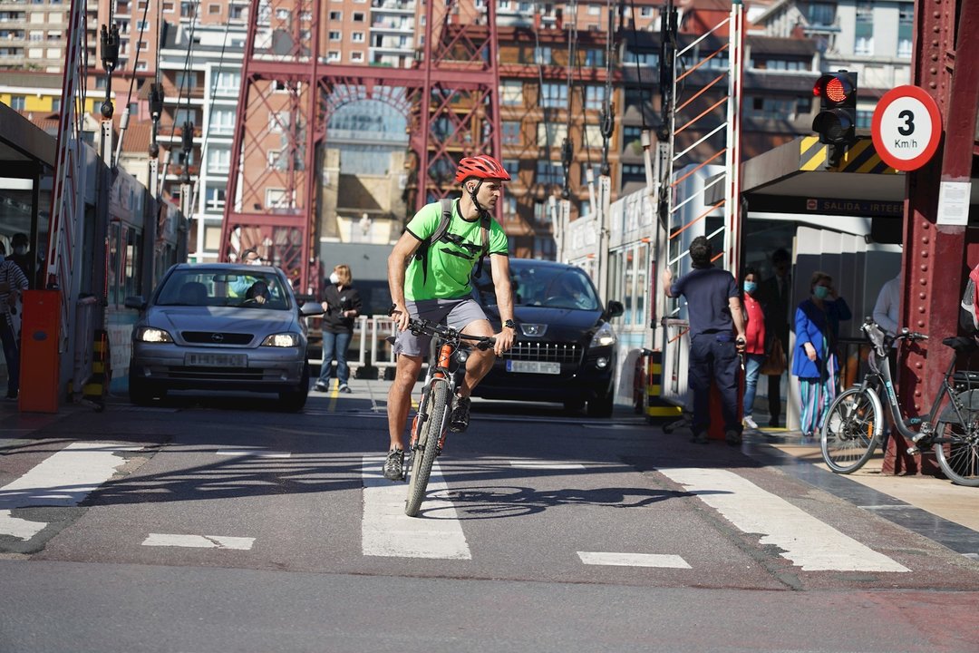 Un ciclista y dos coches cruzan el Puente de Vizcaya