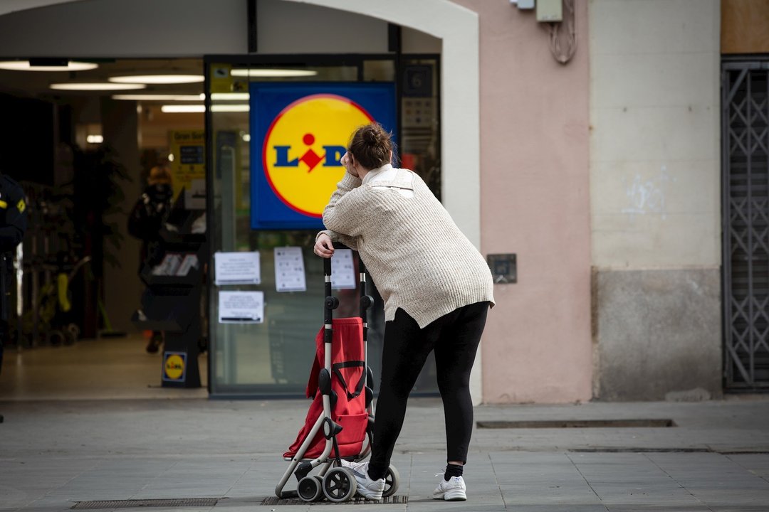 Una mujer espera con su carro de la compra a poder entrar a un supermercado Lidl tras las medidas de aforo impuestas por seguridad, durante el segundo día laborable del estado de alarma por el coronavirus, en Barcelona (España), a 17 de marzo de 2020.