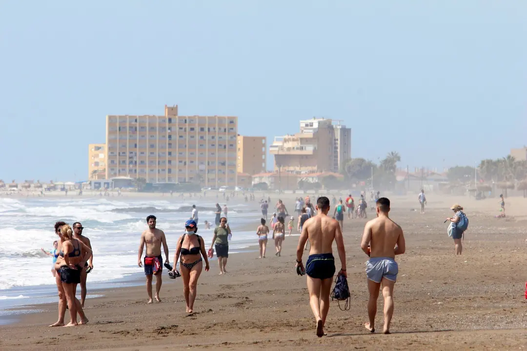 Paseantes disfrutan de la playa de Huel&iacute;n durante la Fase 1 del Estado de Alarma. 