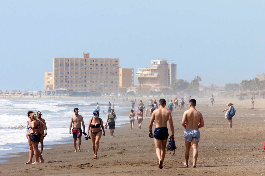 Paseantes disfrutan de la playa de Huelín durante la Fase 1 del Estado de Alarma. 