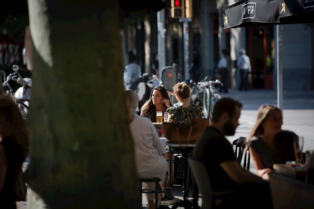 Varias personas disfrutan en la terraza de un bar durante el segundo día de la reapertura al público de las terrazas al aire libre de los establecimientos de hostelería y restauración. En Barcelona, Catalunya (España) a 26 de mayo de 2020.