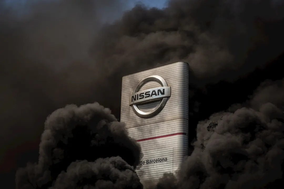 Trabajadores de la planta de producci&oacute;n de Nissan en Barcelona queman neum&aacute;ticos en el exterior de la f&aacute;brica en la Zona Franca el d&iacute;a en el que fabricante japon&eacute;s de autom&oacute;viles, como parte de su nuevo plan estrat&eacute;gico a medio plazo, ha decidido cerrarla