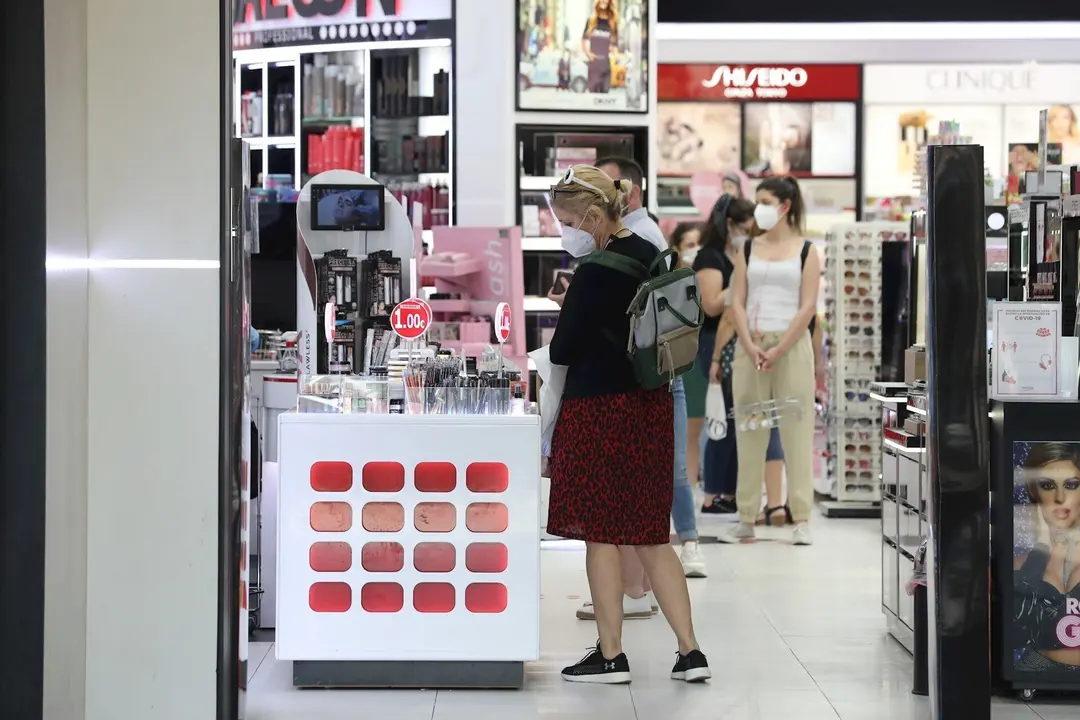Varias personas con mascarilla en una perfumer&iacute;a abierta en el primer d&iacute;a de la fase 1 en Madrid.