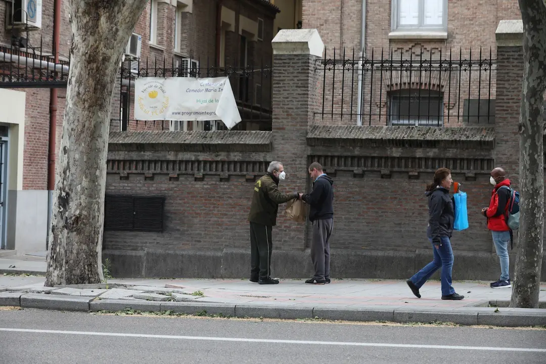 Varias personas esperan en cola para entrar en el comedor de las Hijas de la Caridad de San Vicente de Pa&uacute;l en el madrile&ntilde;o barrio de Chamber&iacute;, a 28 de abril de 2020.