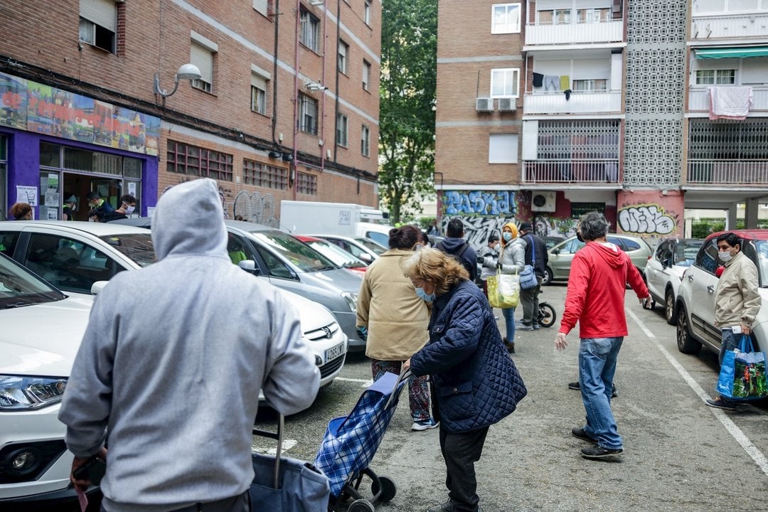 Vecinos realizan una cola para recoger bolsas de la Asociación de Vecinos Parque Aluche. En Aluche, Madrid, (España), a 16 de mayo de 2020.