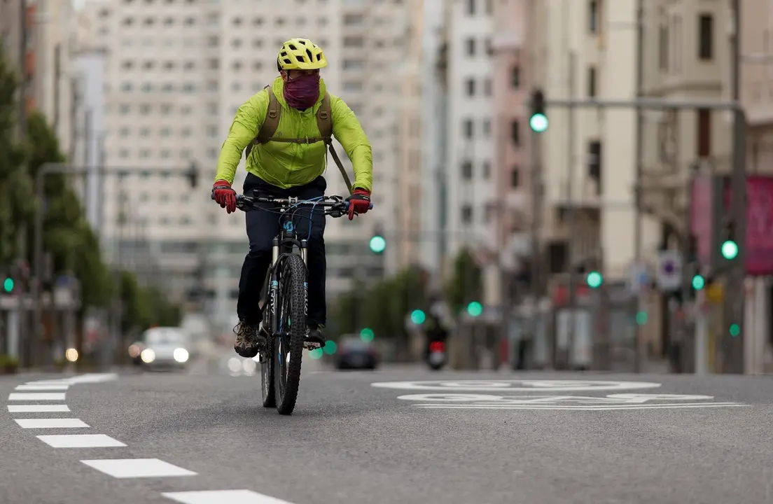 Un hombre monta en bicicleta por la Gran V&iacute;a de Madrid durante el estado de alarma
