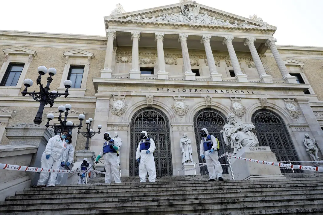 Agentes de la UME con mochilas nebulizadoras en la desinfecci&oacute;n de las escaleras de la entrada de la Biblioteca Nacional