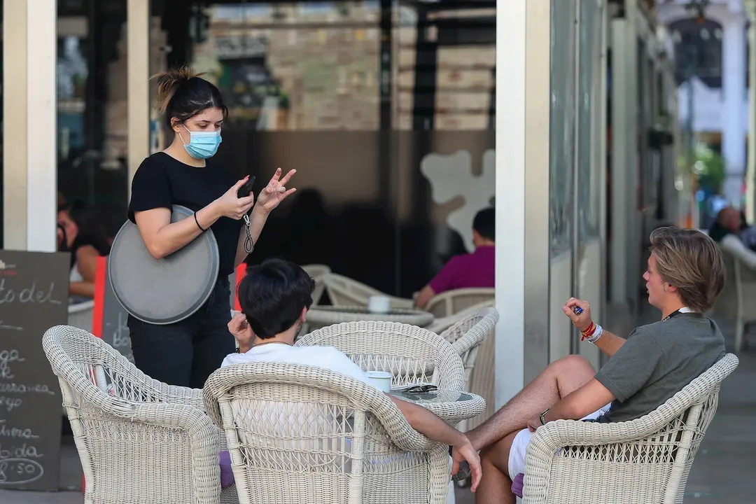 Varias personas piden consumiciones en una terraza en el Mercado de Col&oacute;n durante la fase 2 de la desescalada en la pandemia de coronavirus COVID19. 