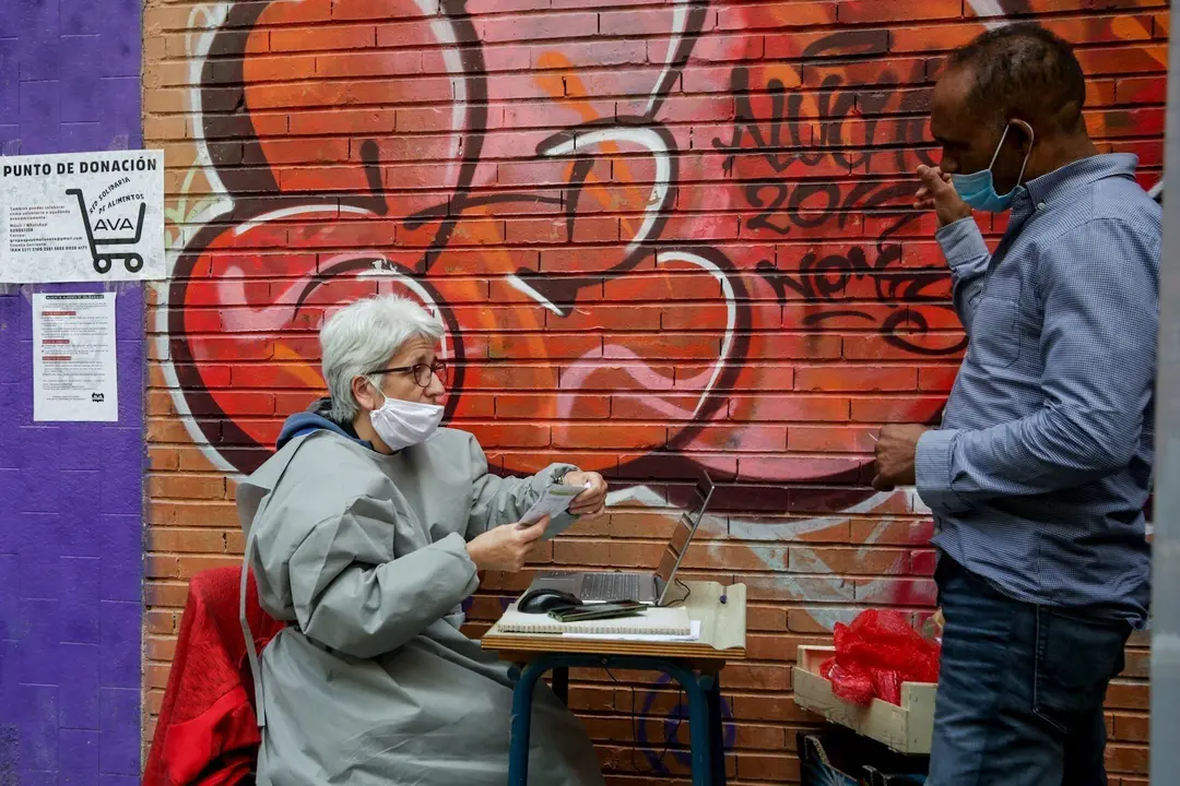 Voluntarios de la Asociaci&oacute;n de Vecinos Parque Aluche, en el reparto de cajas de alimentos y producto. En Aluche, Madrid, (Espa&ntilde;a), a 16 de mayo de 2020.