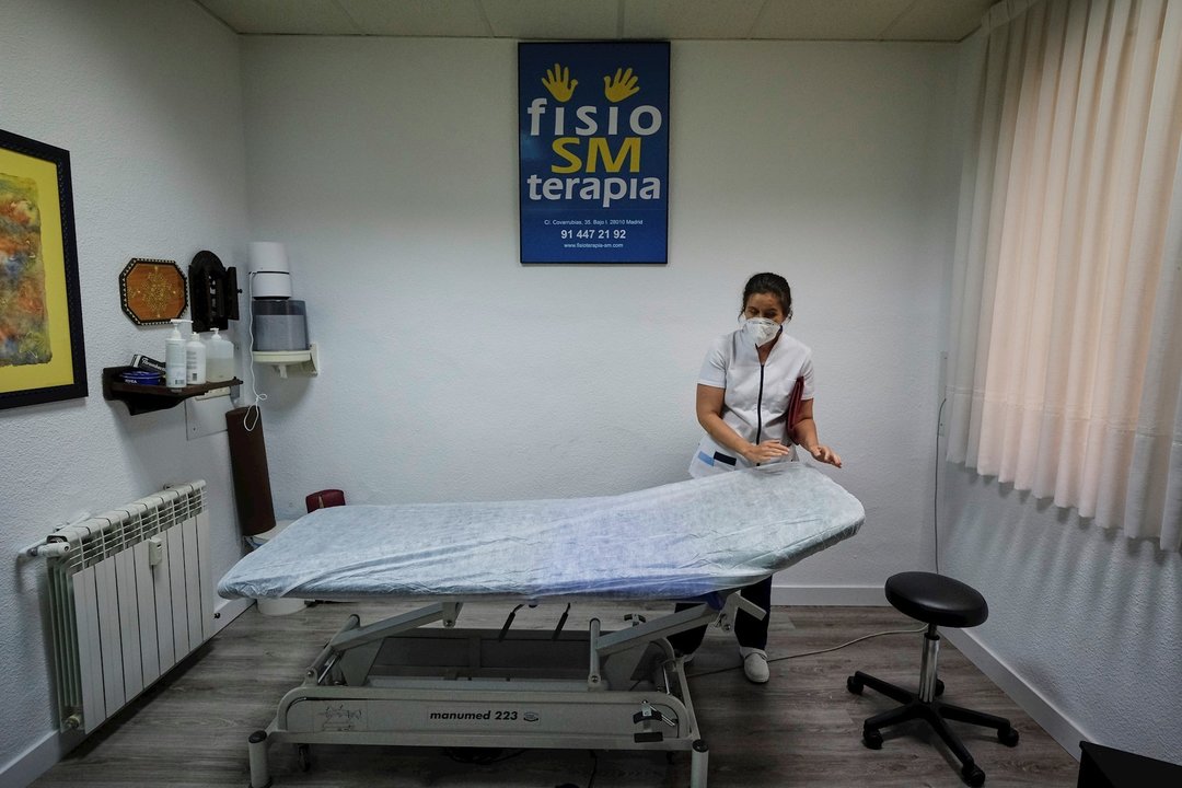 Una fisioterapeuta ciega de la Clínica Fisio SM Terapia (calle Covarrubias, 35) prepara la camilla de un paciente en el primer día de la fase 1 de la desescalada en Madrid. En Madrid (España), a 25 de mayo de 2020.