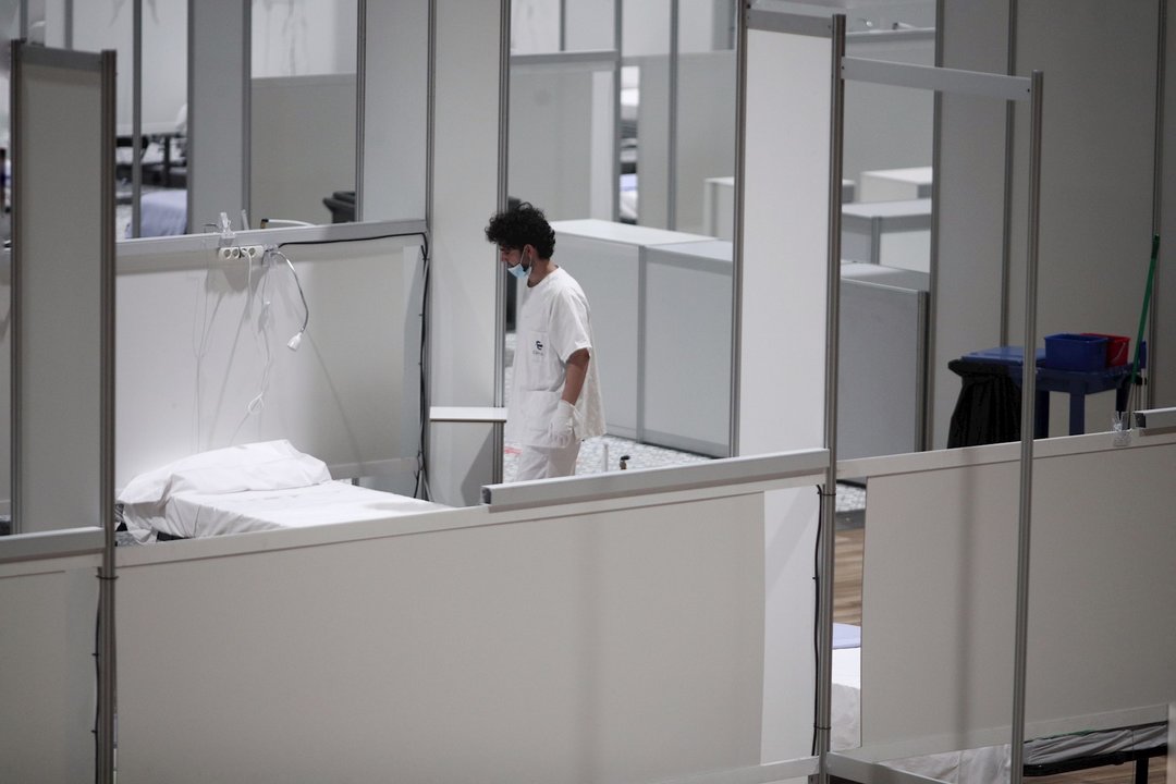 Un profesional sanitario frente a una cama vacía en el interior del hospital de campaña de IFEMA durante su último día de funcionamiento por la bajada de la presión asistencial. En Madrid (España) a 30 de abril de 2020.