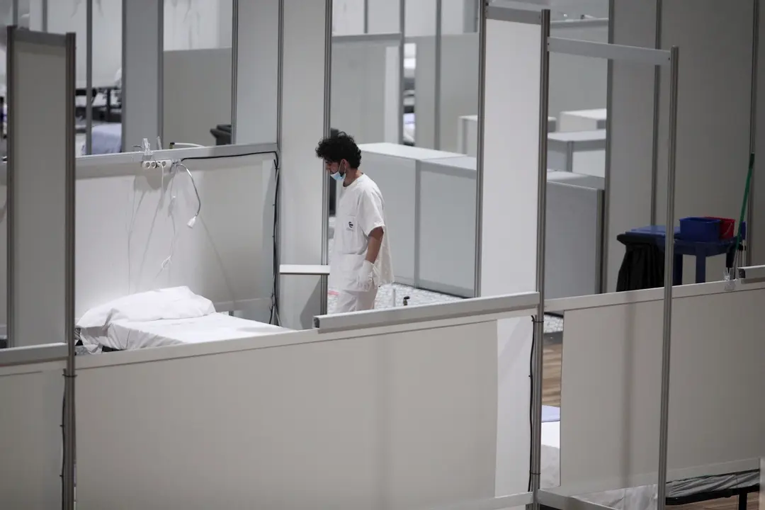 Un profesional sanitario frente a una cama vac&iacute;a en el interior del hospital de campa&ntilde;a de IFEMA durante su &uacute;ltimo d&iacute;a de funcionamiento por la bajada de la presi&oacute;n asistencial. En Madrid (Espa&ntilde;a) a 30 de abril de 2020.