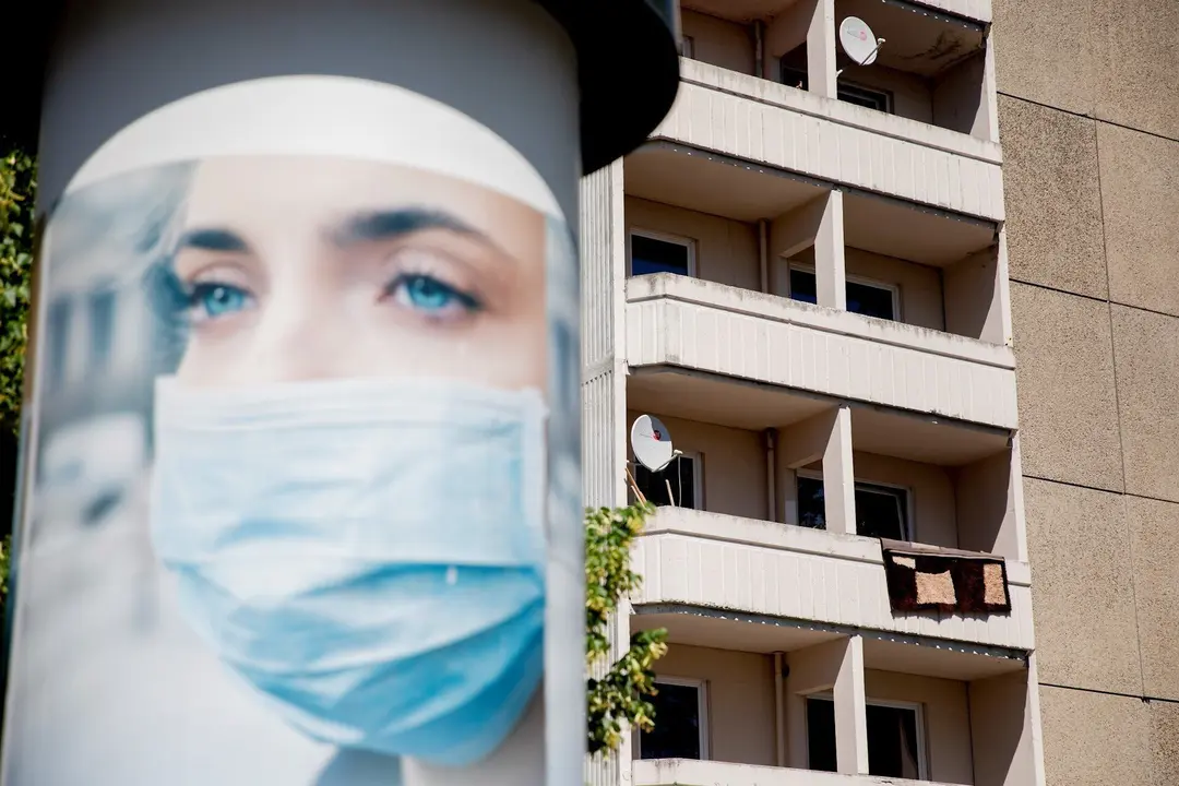 Un anuncio de mascarillas cerca de un bloque de apartamentos en cuarentena en Berl&iacute;n