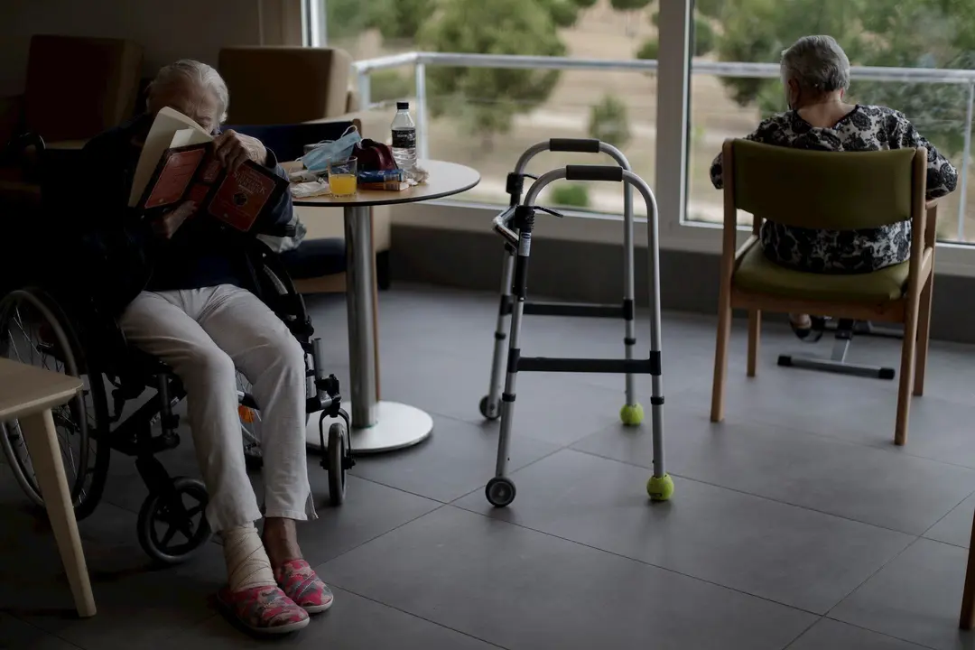 Dos residentes del Centro de Mayores Casablanca Villaverde (Av. de Rafaela Ybarra, 135) leen y descansan en un sal&oacute;n del centro cuatro d&iacute;as despu&eacute;s de que se decretase el fin del estado de alarma por el COVID-19.