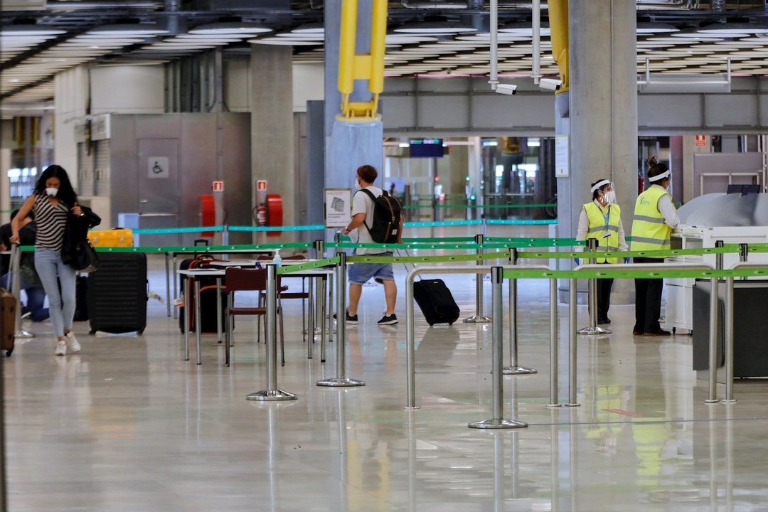 Pasajeros procedentes de Londres caminan entre los pasillos delimitados, antes de rellenar un formulario, a su llegada al Aeropuerto de Madrid-Barajas Adolfo Suárez, como medida de control de los casos sospechosos de coronavirus cuatro días después desde 