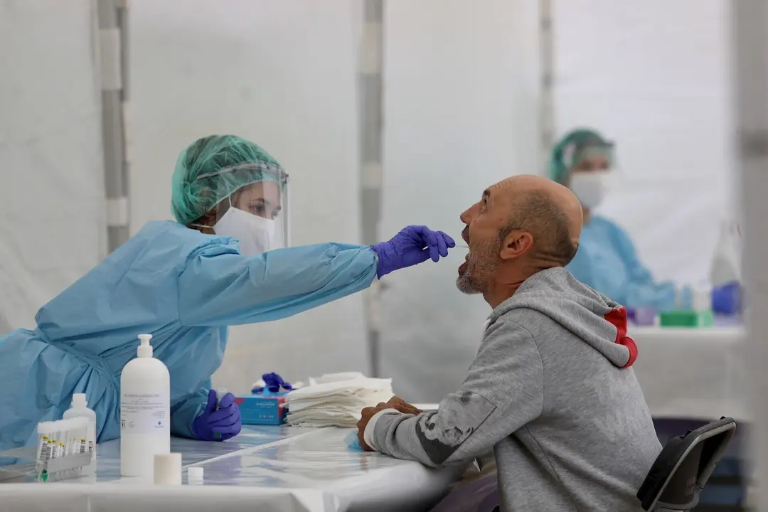 Una sanitaria le realiza un frotis bucal a un vecino 