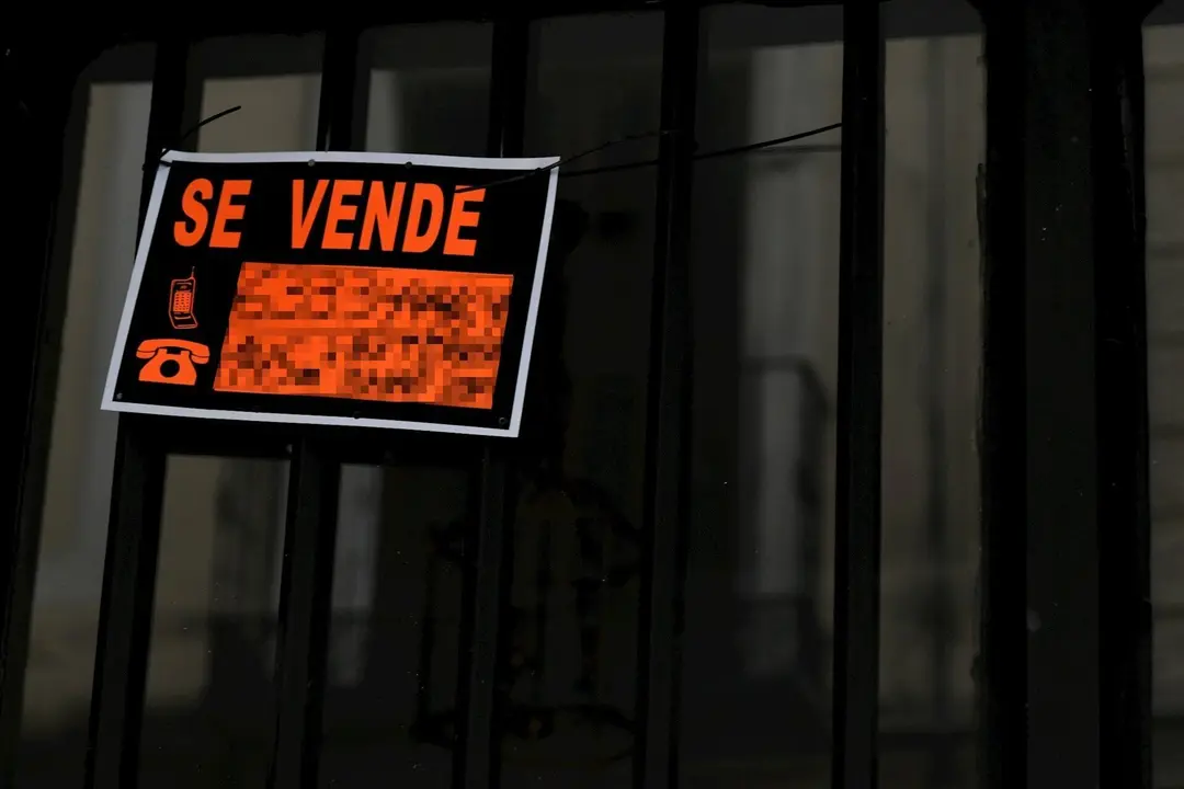 Cartel colgado en un edificio que indica que el inmueble est&aacute; en venta