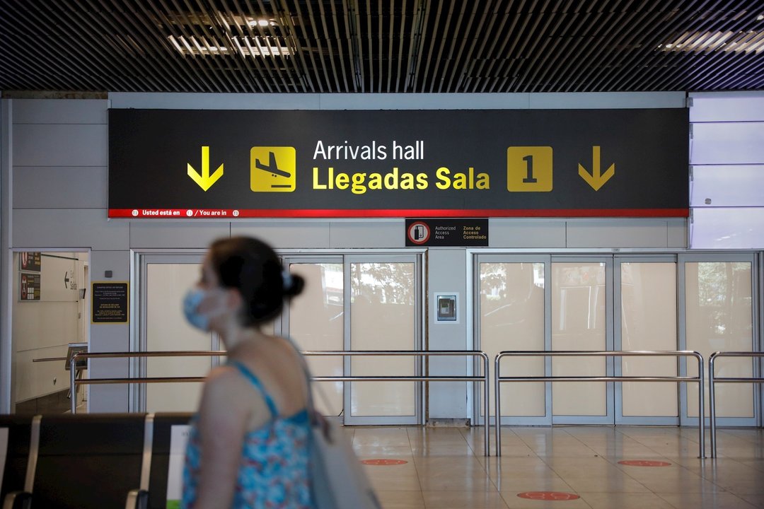 Una persona con mascarilla pasa junto a la entrada de la sala de llegadas 1 de la Terminal 1 del Aeropuerto de Barajas, en Madrid (España) a 4 de julio de 2020.