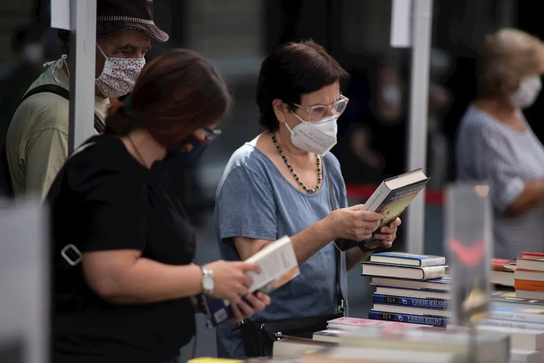 Varios personas observan libros en varios puestos de libros colocados en la calle, en Barcelona, Catalunya (Espa&ntilde;a), a 23 de julio de 2020. 