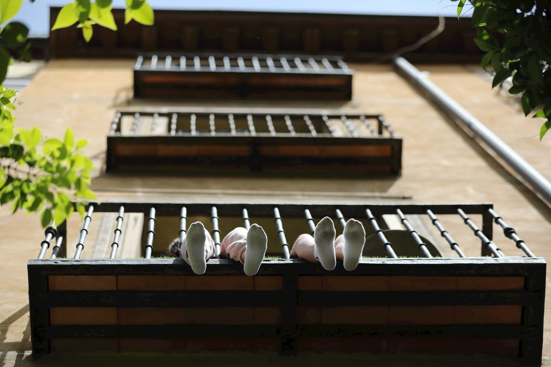 Los pies de unos niños se asoman por su balcón durante el día 53 del estado de alarma por la crisis del Covid-19. En Madrid, (España), a 6 de mayo de 2020.