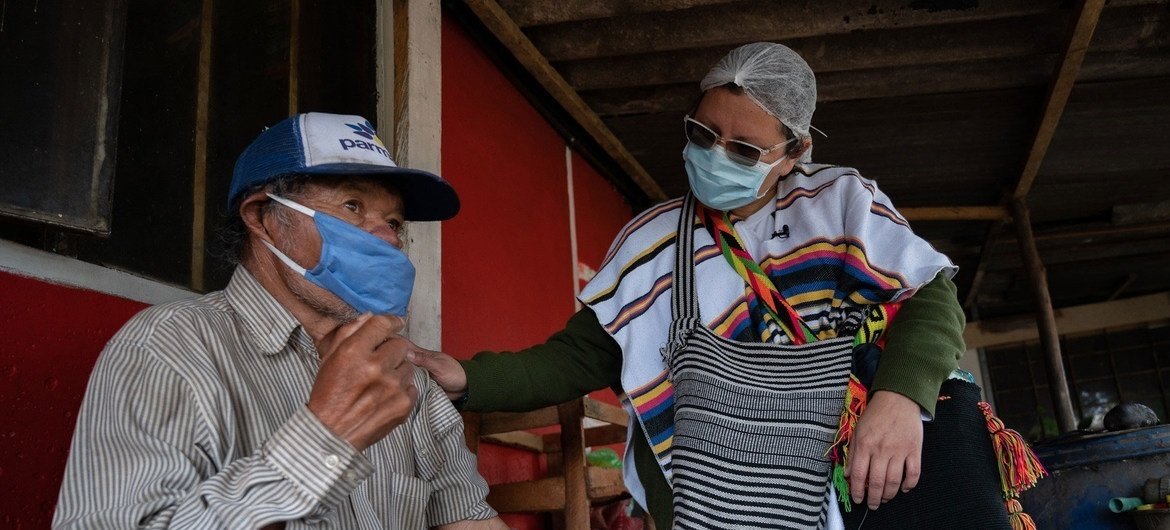 Una enfermera revisa a un hombre de origen indígenas en Suba, Bogotá, durante la pandemia de COVID-19.