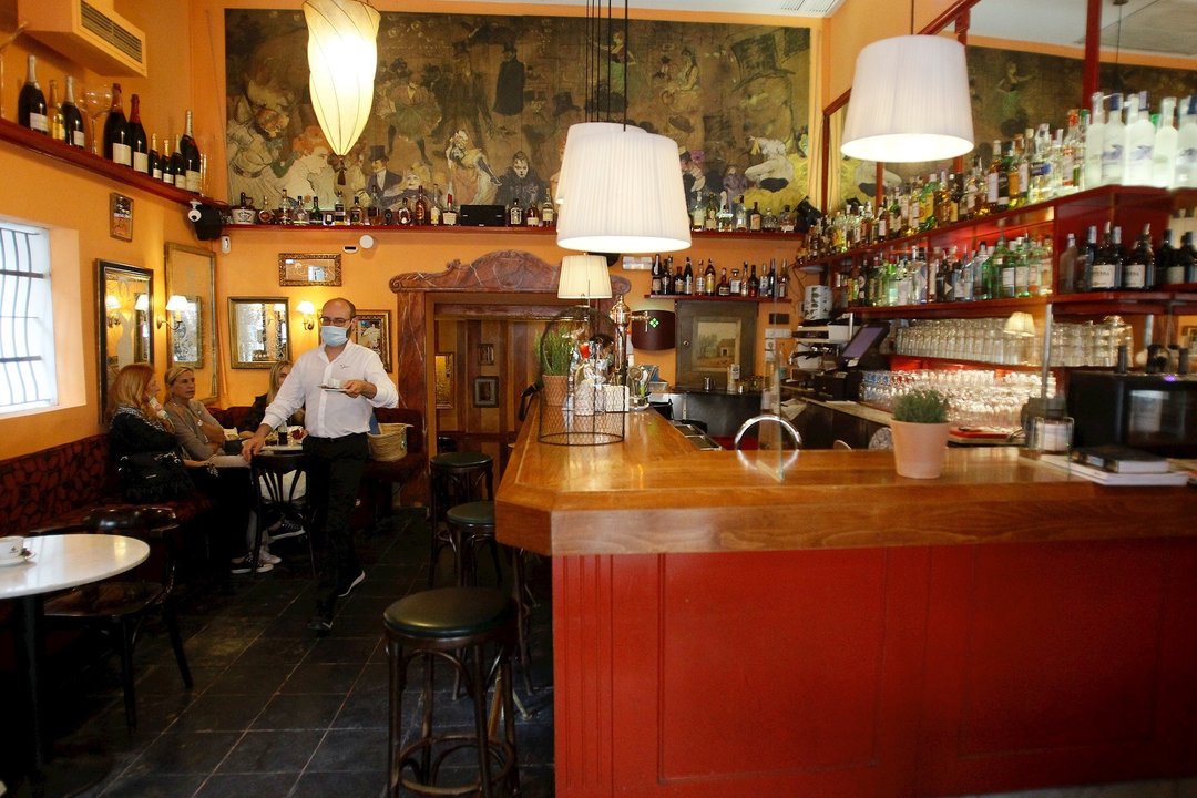 Una camarero sirve una mesa en un bar de Palma de Mallorca