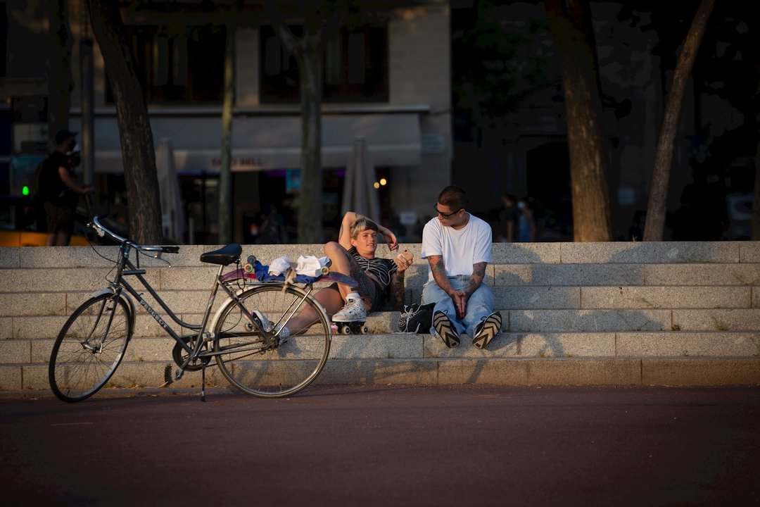Dos jóvenes junto a una bicicleta en Barcelona, Catalunya (España), a 28 de julio de 2020.