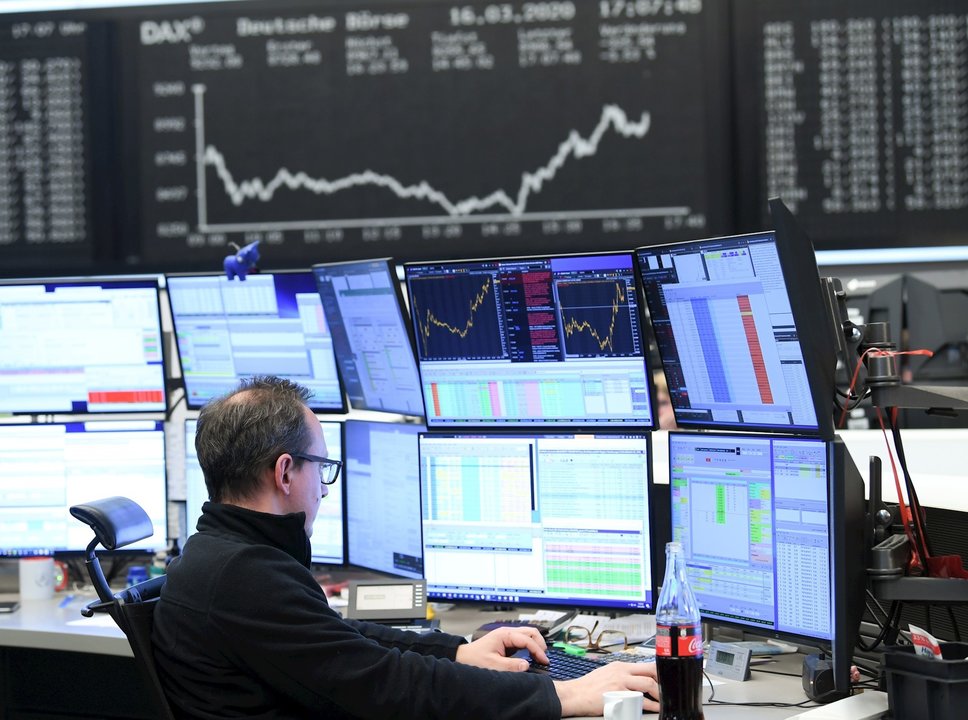 16 March 2020, Frankfurt/Main: A stock trader sits in front of his monitors in the trading room of the Frankfurt Stock Exchange. As a result of the worsening coronavirus crisis, the German share index Dax has fallen below the 9000 point mark. Photo: Arne 