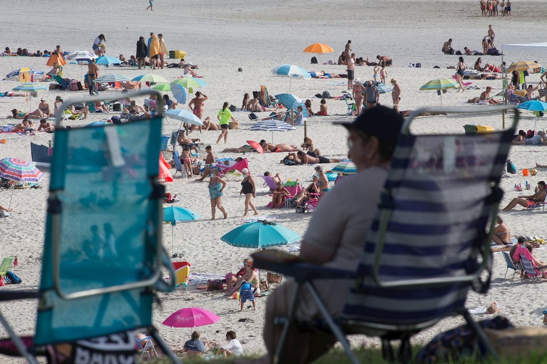 Una persona sentada frente a la playa en A Mariña (Lugo/Galicia) a 27 de julio de 2020. La comarca mantiene este domingo 51 casos activos de COVID-19 tras una nueva alta y un nuevo contagio con respecto al sábado.