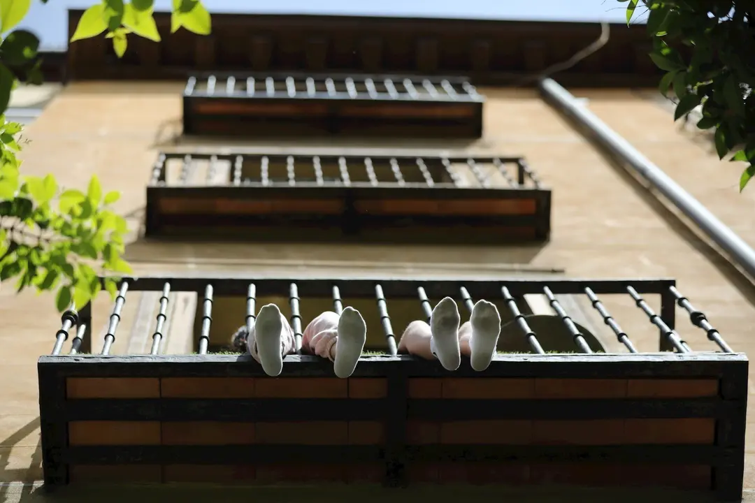 Los pies de unos ni&ntilde;os se asoman por su balc&oacute;n durante el d&iacute;a 53 del estado de alarma por la crisis del Covid-19. En Madrid, (Espa&ntilde;a), a 6 de mayo de 2020