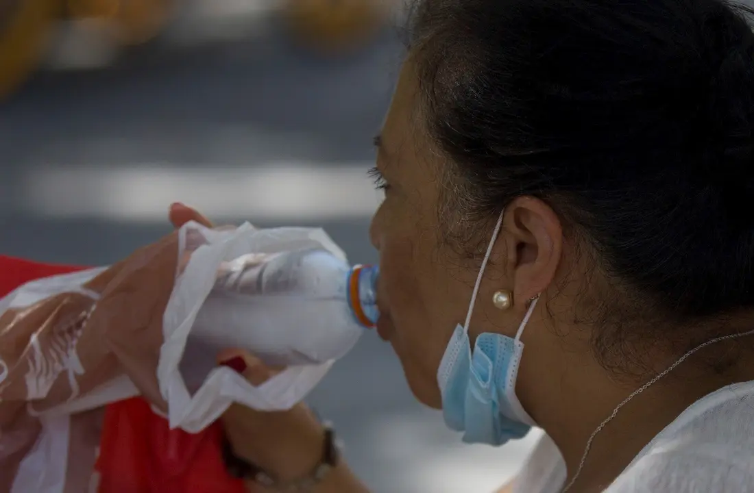 Una mujer bebiendo agua durante la ola de calor africano del pasado 30 de julio de 2020.