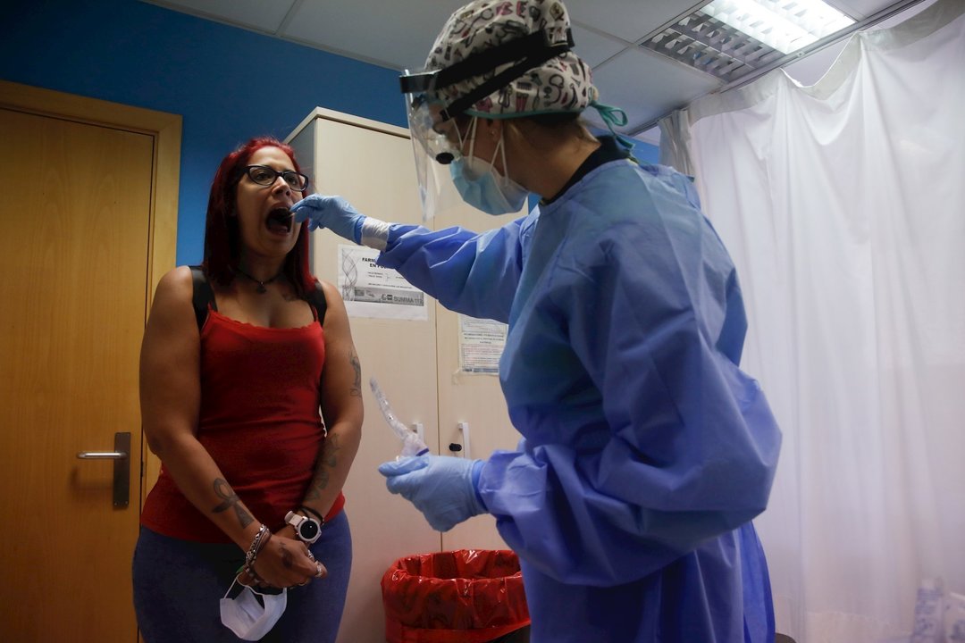 Una trabajadora sanitaria realiza una prueba PCR a una de las personas que ha acudido durante la jornada de hoy a realizarse un test al dispositivo instalado en el Centro de Especialidades El Arroyo, en Fuenlabrada, Madrid, (España), a 27 de agosto de 202