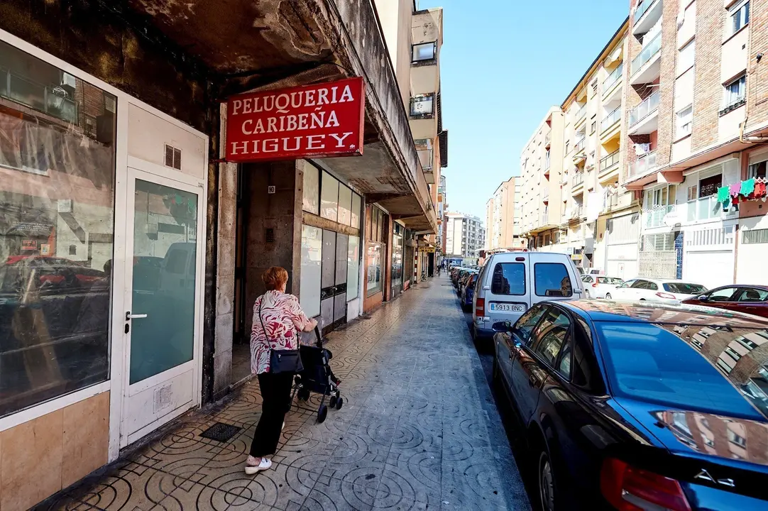 Una mujer pasea por las calles del barrio La Inmobiliaria de Torrelavega