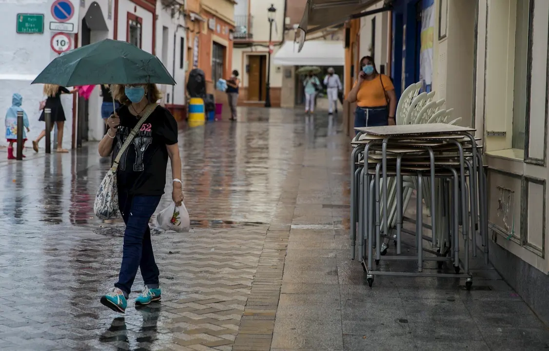 Una mujer se protege de la lluvia bajo su paraguas en Tomares (Sevilla, Andaluc&iacute;a, Espa&ntilde;a), a 18 de septiembre de 2020.
