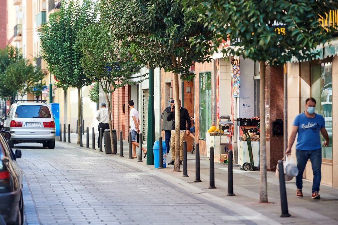 Transeúntes pasean por las calles del barrio La Inmobiliaria de Torrelavega, en Cantabria, 