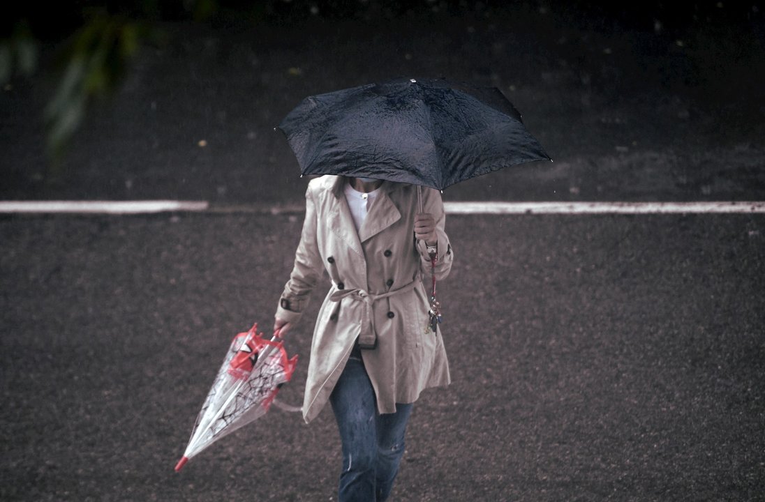 Una persona camina bajo la lluvia protegida con un paraguas, en Madrid (España) a 24 de septiembre de 2020. La ciudad ha registrado un chubasco intenso este jueves entre las 08.30 y las 10.00 horas en el que se han acumulado entre 17 y 19 litros por metro
