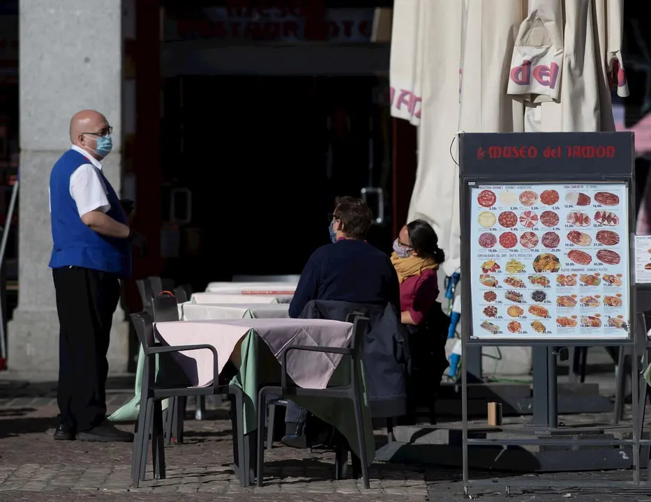 Un camarero atiende la terraza de un establecimiento ubicado en la Plaza Mayor durante el primer d&iacute;a con nuevas restricciones en la movilidad, en Madrid, (Espa&ntilde;a), a 3 de octubre de 2020.