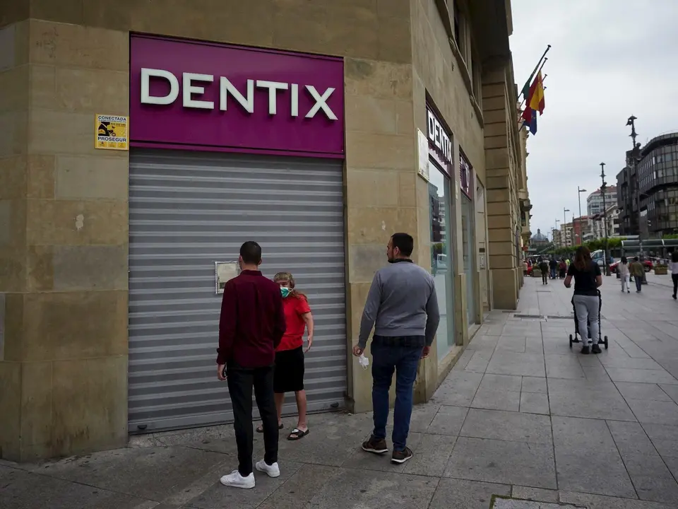 Una mujer se apoya en la puerta de una cl&iacute;nica Dentix para conocer si est&aacute; abierta . En Pamplona, Navarra (Espa&ntilde;a), a 25 de mayo de 2020.