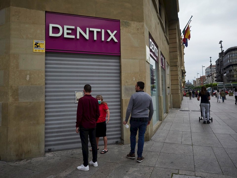 Una mujer se apoya en la puerta de una clínica Dentix para conocer si está abierta . En Pamplona, Navarra (España), a 25 de mayo de 2020.