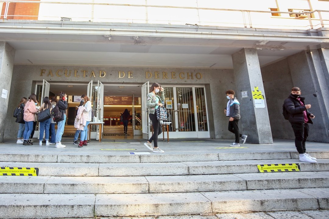 Varios jóvenes charlan antes de entrar a clase en la Facultad de Derecho de la UCM, en el Campus Universitario de Moncloa, en Ciudad Universitaria (Madrid)