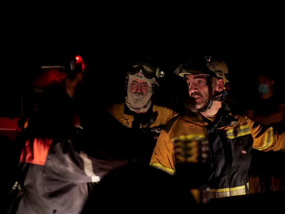 Efectivos de bomberos trabajando para extinguir un incendio forestal producido entre las localidades de Gazolaz y Arazuri, a escasos 5 kil&oacute;metros de Pamplona, donde han llegado el humo y las cenizas. En Gazolaz (Navarra), a 8 de agosto de 2020.