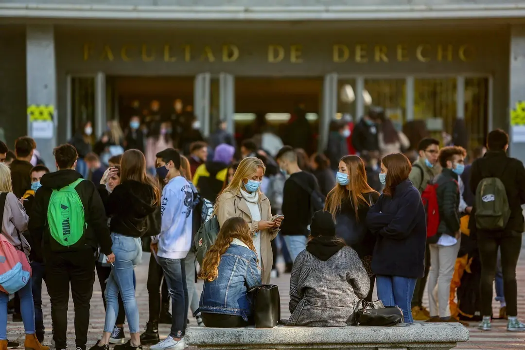 Varios j&oacute;venes charlan antes de entrar a clase en la Facultad de Derecho de la Universidad Complutense en el Campus Universitario de Moncloa en Ciudad Universitaria, en Madrid
