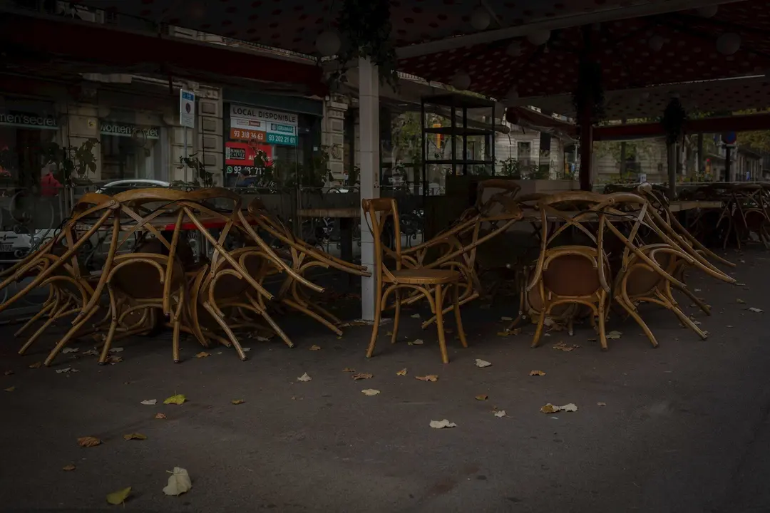 Sillas recogidas de una terraza de un bar cerrado 