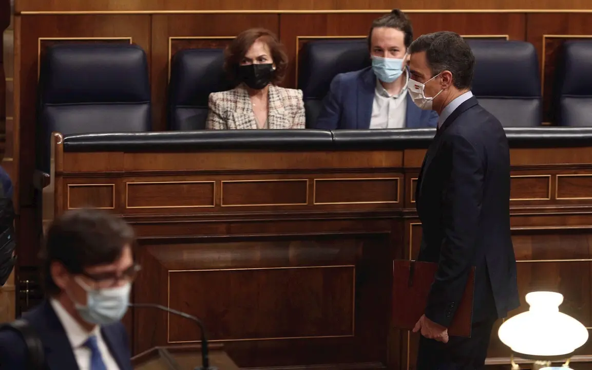 El presidente del Gobierno, Pedro S&aacute;nchez, pasa por delante de vicepresidenta primera del Gobierno, Carmen Calvo, y vicepresidente segundo del Gobierno, Pablo Iglesias, durante una sesi&oacute;n de control al Gobierno en el Congreso, en Madri, a 28 de octubre
