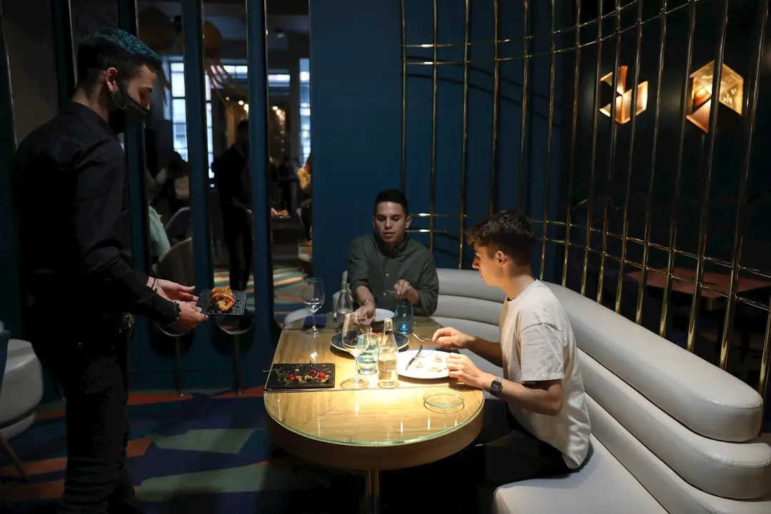 Un camarero sirve a dos comensales de una mesa del Restaurante Marta, Cari&ntilde;o!, en Madrid (Espa&ntilde;a), a 16 de octubre de 2020. 